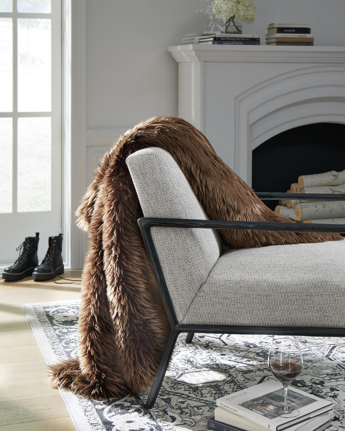 Brown faux fur throw blanket draped over an armchair