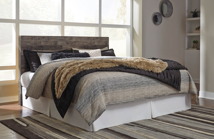 Dark wood panel headboard behind white bed with gray and black throws