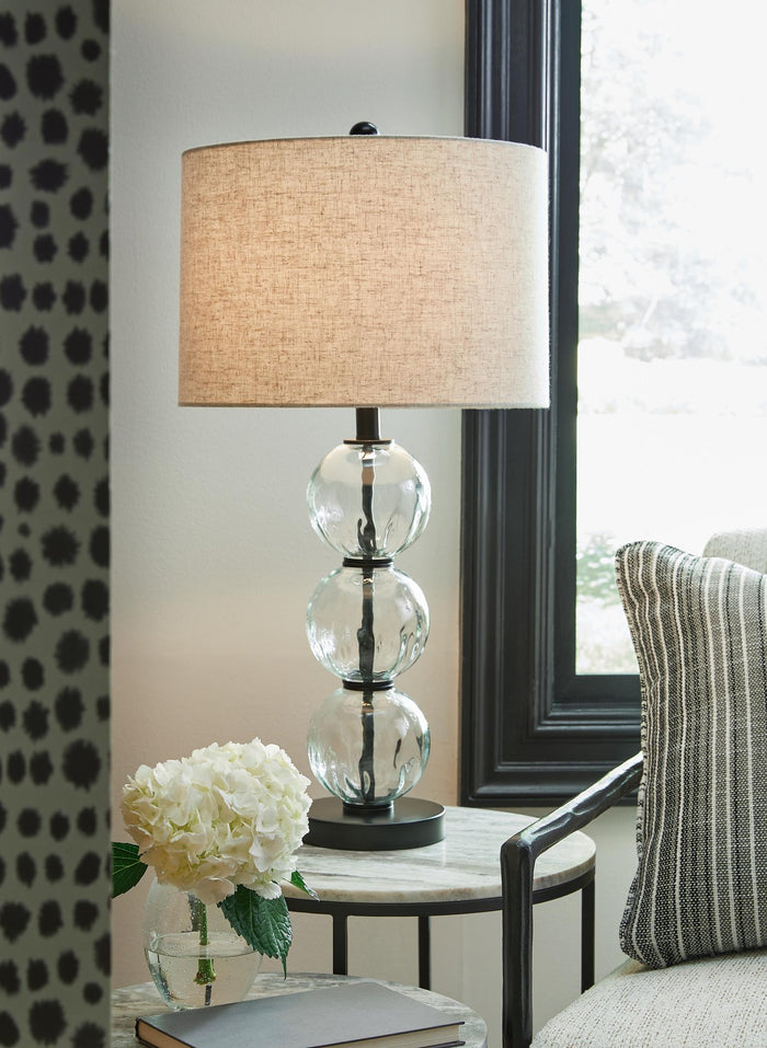 Table lamp with beige fabric shade and clear stacked glass base