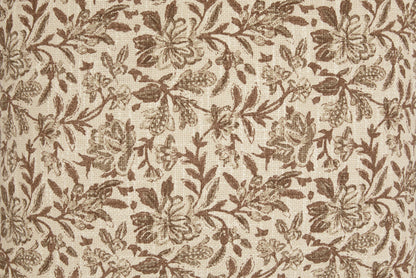 Close-up of tan fabric with brown botanical leaf and flower pattern texture.