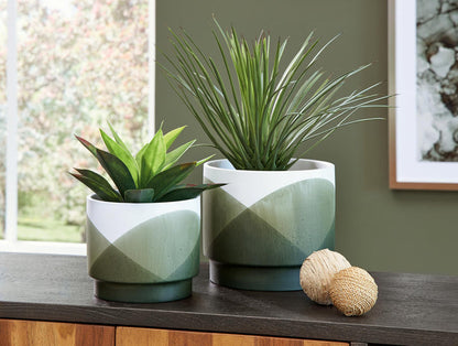 Set of 2 cylindrical planters on table, green base with white top and diagonal pattern