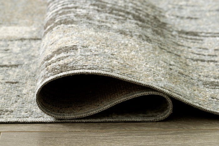 Light gray and ivory area rug corner with rolled edge and textured pile