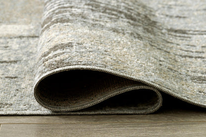 Light gray and ivory area rug corner with rolled edge and textured pile