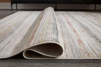 Striped rug edge with visible backing and stitched binding, light gray and tan