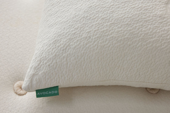Off-white textured pillow corner with green Avocado label