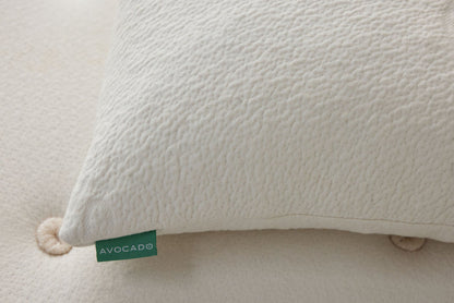 Off-white textured pillow corner with green Avocado label