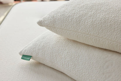 Off-white textured throw pillow with green corner label, close-up