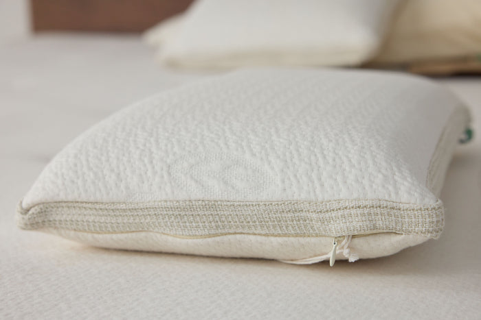 White latex pillow with textured cover and zippered seam, angled close view