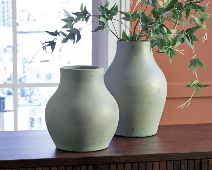 Light sage speckled ceramic vase with flared neck on tabletop, shown beside another vase