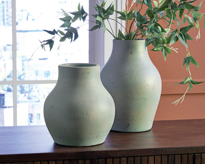 Light sage speckled ceramic vase with flared neck on tabletop, shown beside another vase