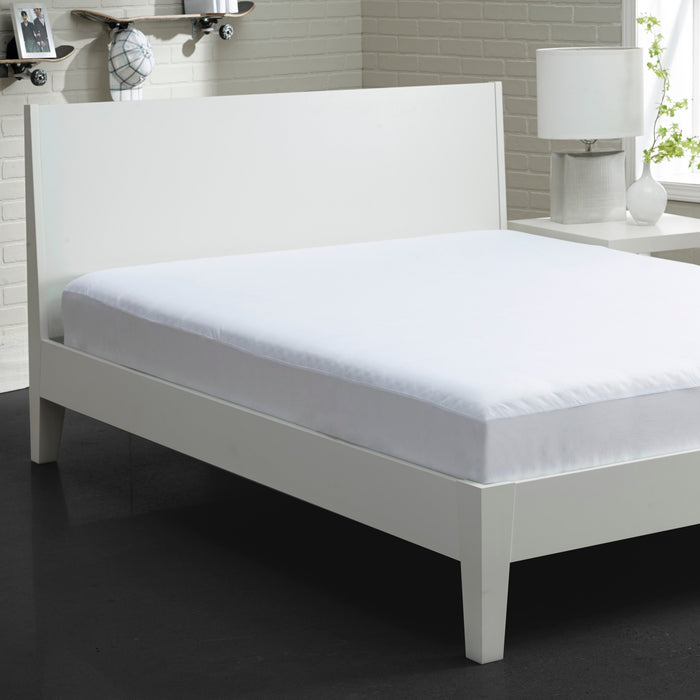 White fitted mattress protector on bed with front skirt edge and corner folds visible