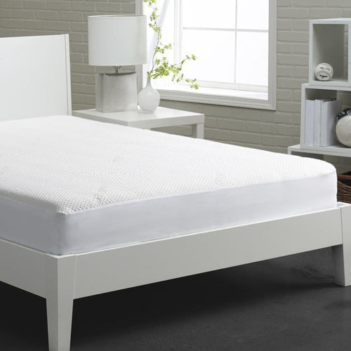 White mattress protector with textured surface, fitted over a mattress on a bed
