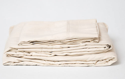 Cream microplush bamboo sheet set folded stack with top fitted sheet edge visible