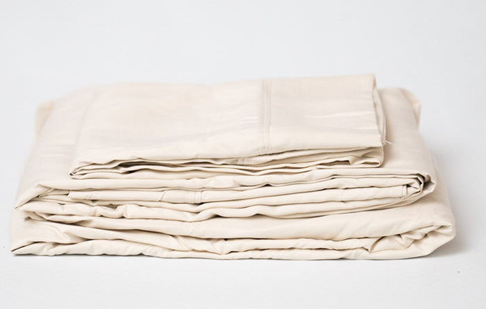Cream microplush bamboo sheet set folded, showing contrasting fold creases