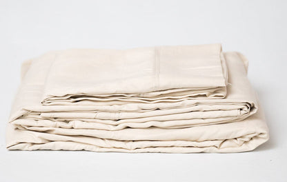 Cream microplush bamboo sheet set folded with layered hems and stitching detail