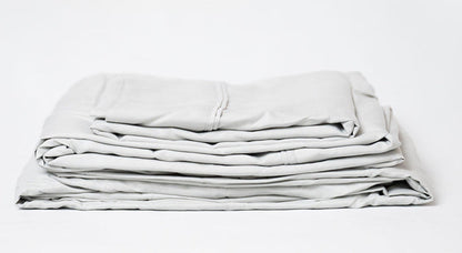 Light gray sheet set, folded stack with visible top seam and stripes