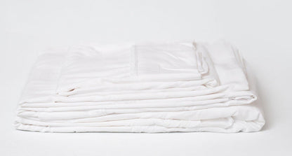 White sheet set folded stack, layered sheets with stitched edges visible