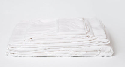 White sheet set in a folded, layered bundle with visible fabric folds