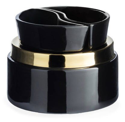 A glossy black ceramic container with a wide polished gold band around the middle, photographed on a clean white background.