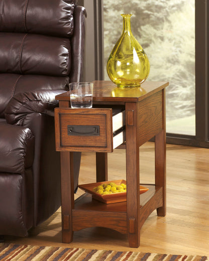Cherry chairside end table with drawer and lower shelf, glass and vase on top.
