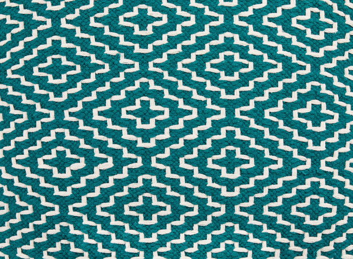 Close-up of teal and cream geometric cross pattern on pouf fabric.