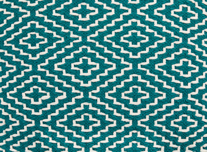 Close-up of teal and cream geometric cross pattern on pouf fabric.