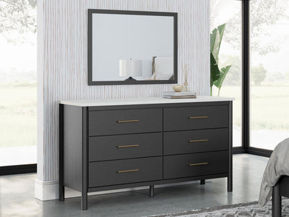 Square dark-framed mirror over black dresser with three double drawers and slim pulls