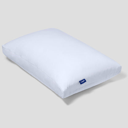 White rectangular Casper logo pillow with a blue tag near the corner.