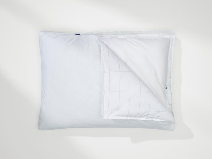 White pillow with cover opened, showing inner grid stitching and blue Casper tag.
