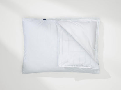 White pillow with cover opened, showing inner grid stitching and blue Casper tag.