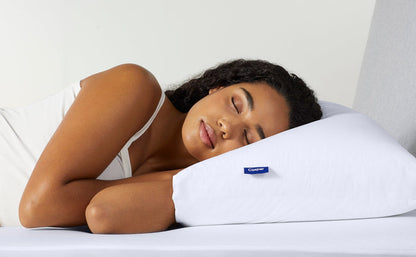 White pillow with blue Casper logo tag supporting a resting person.