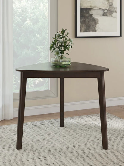 Dark brown triangular dining table with three legs in a living room setting