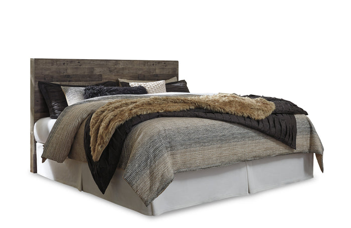 Dark wood panel headboard and white bed base with layered gray and tan bedding