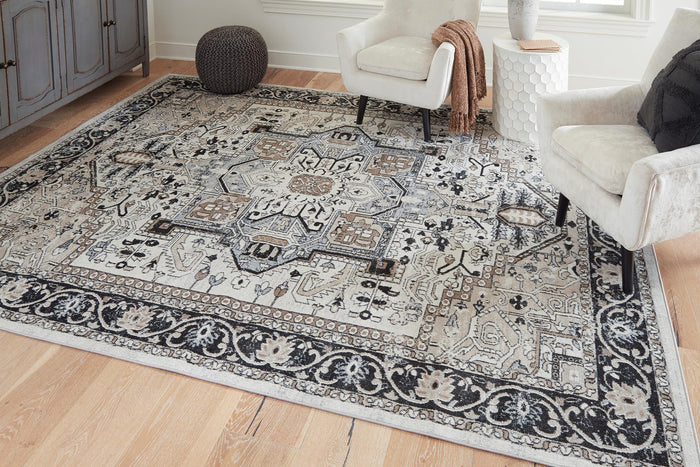 Ornate black-and-gray area rug with repeating motifs in a living room