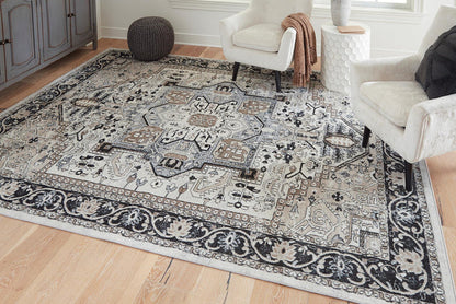 Ornate black-and-gray area rug with repeating motifs in a living room