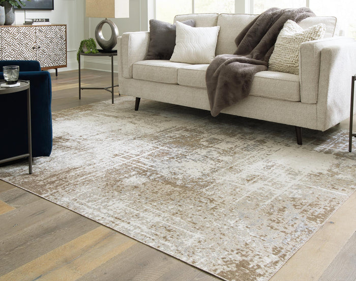 Cream-and-beige distressed area rug, rectangular with worn abstract design.