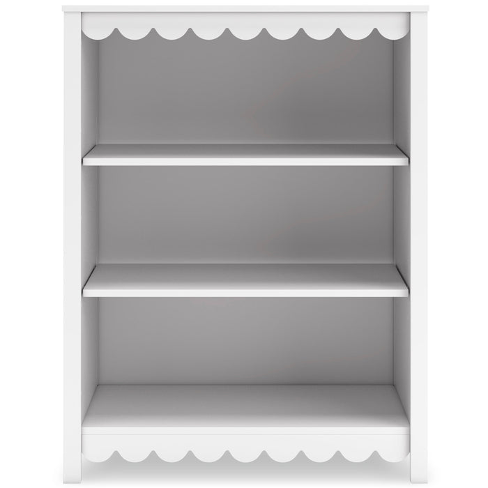 White bookcase with three open shelves and scalloped trim at top and bottom