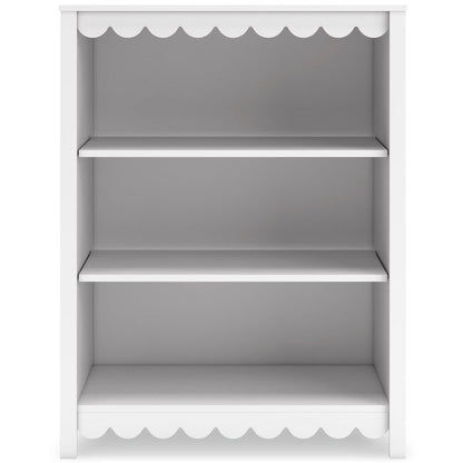 White bookcase with three open shelves and scalloped trim at top and bottom