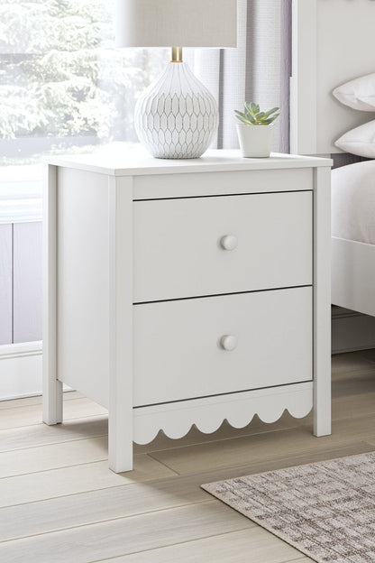 White nightstand with two drawers, round knobs, and scalloped apron