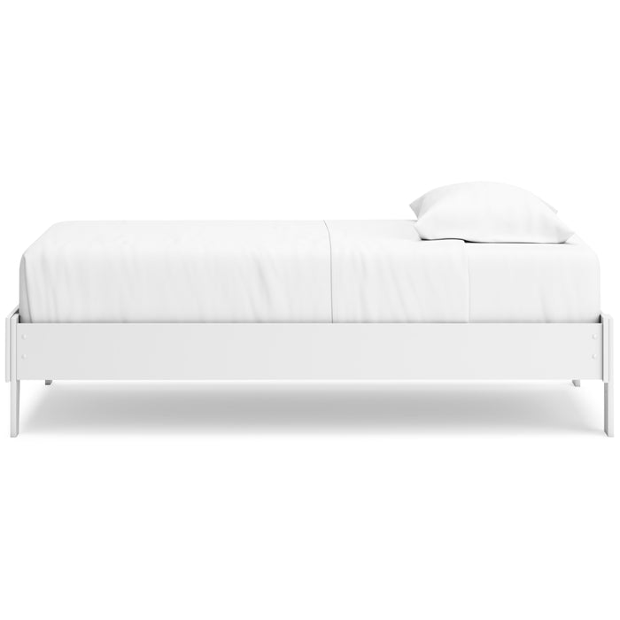 White platform bed side view with low profile frame and stacked cushions