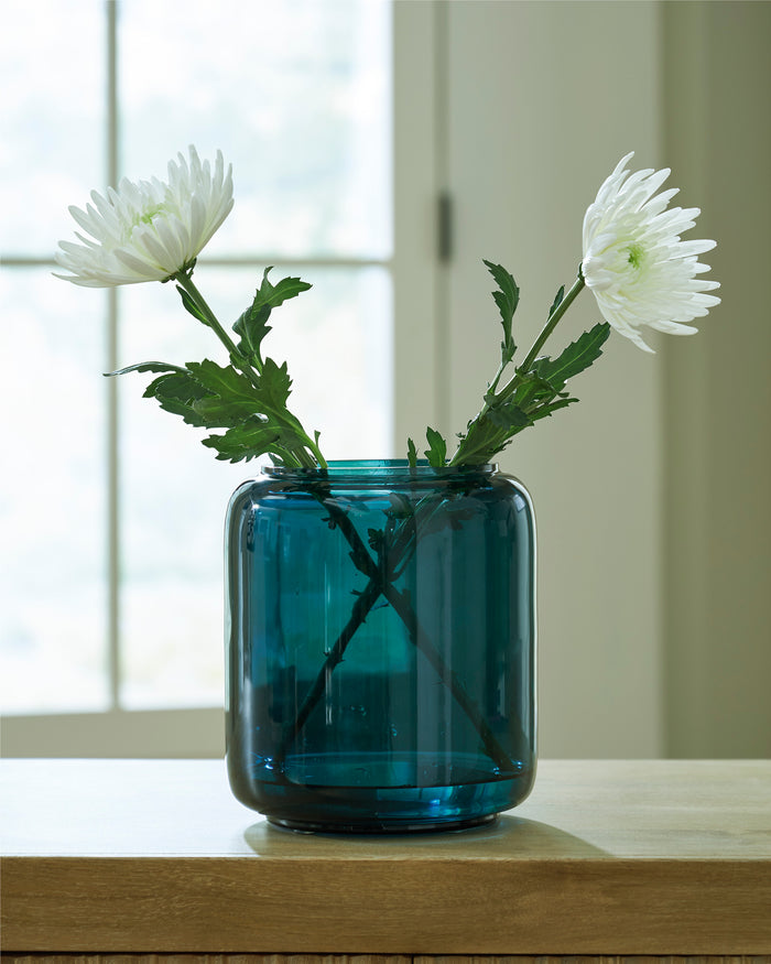Teal glass vase with clear rim, holding white daisies and green stems