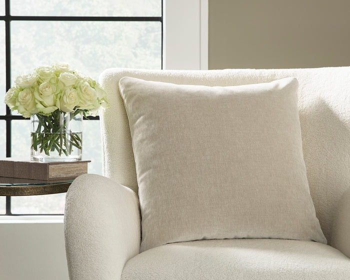 Warm gray throw pillow on a light upholstered chair.