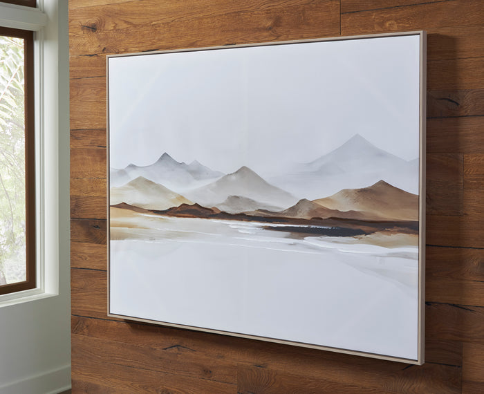 Framed mountain landscape print in a white border, displayed on wooden wall