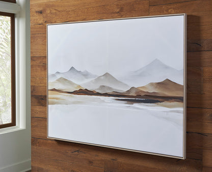 Framed mountain landscape print in a white border, displayed on wooden wall