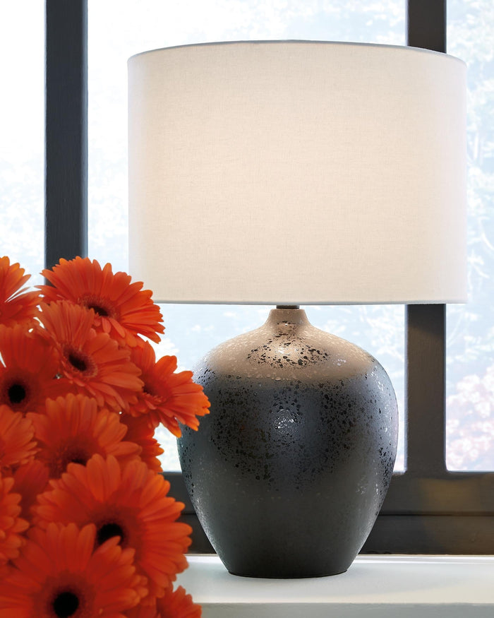 Table lamp with white drum shade and dark speckled ceramic base
