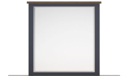 Wall-mounted bedroom mirror with charcoal frame and light wood top trim