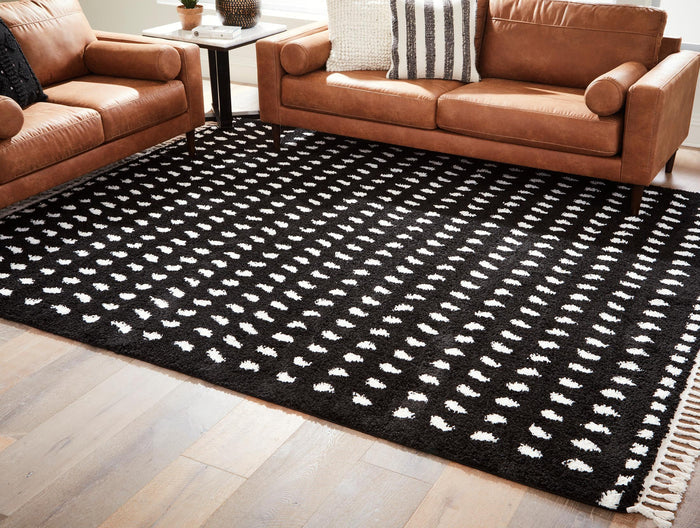 Black area rug with white abstract dash pattern and fringed border