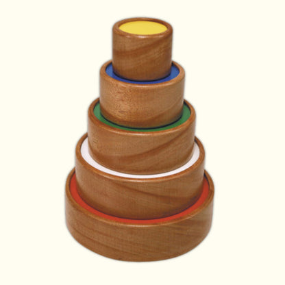 Wooden stacking rings arranged in a tower from largest at the bottom to smallest at the top, with colorful inner circles.