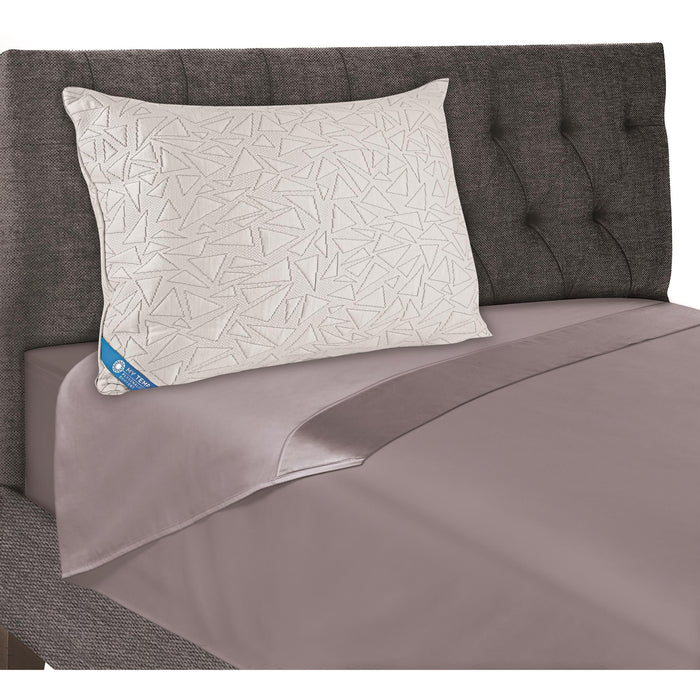 Geometric white cooling pillow on gray bed, with blue corner label