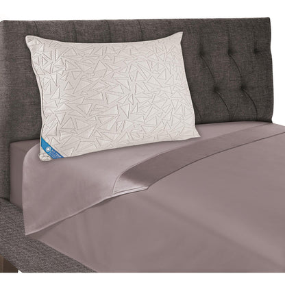 Geometric white cooling pillow on gray bed, with blue corner label